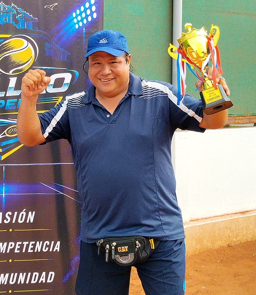 Fotografía real de Fernando Ku sosteniendo un trofeo en un evento deportivo
