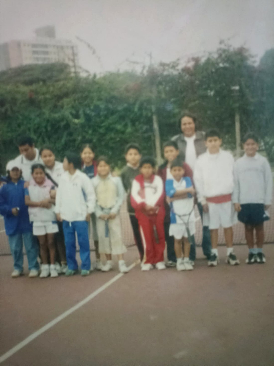 Grupo de alumnos en una cancha de tenis